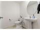 Stylish half-bathroom with a pedestal sink, round mirror, and wainscoting detail at 5383 Companion Ln, Tampa, FL 33619