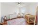 Cozy Bedroom with hardwood floors, a wooden crib, patterned rug, and a white changing table at 5383 Companion Ln, Tampa, FL 33619