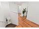 Hallway with wood flooring, leading to other rooms, adorned with a tall potted plant and mirror at 5383 Companion Ln, Tampa, FL 33619