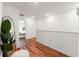 Upstairs hallway featuring wood floors, white walls, and stylish decorations at 5383 Companion Ln, Tampa, FL 33619