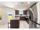 Bright kitchen boasts stainless steel appliances, granite counters, an island, and a door to the backyard at 5383 Companion Ln, Tampa, FL 33619