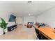 Open-concept living room featuring tile flooring, a sectional sofa, and a large TV at 5383 Companion Ln, Tampa, FL 33619