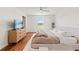 Well-lit main bedroom features hardwood floors, a ceiling fan, television and plenty of natural light at 5383 Companion Ln, Tampa, FL 33619