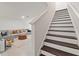 Staircase leading to living room with comfortable seating, a round ottoman and a cozy rug at 5383 Companion Ln, Tampa, FL 33619