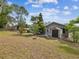 Landscaped backyard with shed and view of the enclosed pool at 5411 Joyner Ave, Spring Hill, FL 34608