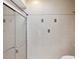 Clean bathroom featuring a glass-enclosed shower with decorative tile accents, toilet, and grab bar at 5411 Joyner Ave, Spring Hill, FL 34608