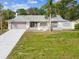 Charming single-story home featuring an attached two-car garage, a well-manicured lawn, and mature landscaping at 5411 Joyner Ave, Spring Hill, FL 34608
