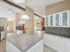 Kitchen with white cabinets, mosaic backsplash, and an island with views of the living room at 5411 Joyner Ave, Spring Hill, FL 34608