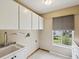 Utility sink and counter space in bright laundry room with window at 5411 Joyner Ave, Spring Hill, FL 34608