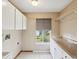 Bright laundry room with overhead storage and ample counter space at 5411 Joyner Ave, Spring Hill, FL 34608
