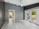 Bright sunroom with gray wood walls, white trim, and stylish ceiling fan at 5411 Joyner Ave, Spring Hill, FL 34608