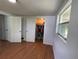 Bright bedroom featuring wood floors, a walk-in closet, and natural light from the window at 5736 Colonial Dr, New Port Richey, FL 34653
