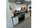 A modern kitchen features stainless steel appliances, granite countertops, and white cabinets at 5736 Colonial Dr, New Port Richey, FL 34653
