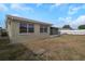 Backyard of home featuring a screen patio, lawn, and privacy fence at 6206 11Th Ave, New Port Richey, FL 34653