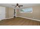 Bedroom featuring wood floors, a ceiling fan, and a window providing natural light at 6206 11Th Ave, New Port Richey, FL 34653