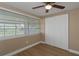 Well-lit bedroom featuring hardwood floors, a ceiling fan, and a spacious closet at 6206 11Th Ave, New Port Richey, FL 34653
