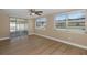 Bedroom with natural light, wood floors, ceiling fan, and screened-in lanai access at 6206 11Th Ave, New Port Richey, FL 34653