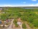 Expansive aerial shot showcasing lush green surroundings, homes, and lake in the distance at 6418 E 23Rd Ave, Tampa, FL 33619
