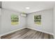 Bright bedroom featuring wood-look flooring, crisp white trim, and a ductless AC unit at 6418 E 23Rd Ave, Tampa, FL 33619