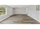 Updated living area featuring gray wood-look flooring and fresh paint at 6418 E 23Rd Ave, Tampa, FL 33619