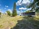 Large grassy backyard with a tall tree and screened-in patio at 6431 Gainsboro Dr, Port Richey, FL 34668