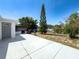 A spacious backyard featuring a concrete patio, screened area, mature landscaping, and a small grill at 6431 Gainsboro Dr, Port Richey, FL 34668