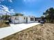 View of the backyard featuring a grill, partially screened porch, and a concrete patio area at 6431 Gainsboro Dr, Port Richey, FL 34668