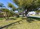 Single-story home boasts a brick facade, spacious driveway, and a well-manicured lawn with mature trees at 6431 Gainsboro Dr, Port Richey, FL 34668