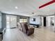 Spacious living room featuring laminate floors, a comfortable sofa, TV, and lots of natural light at 6431 Gainsboro Dr, Port Richey, FL 34668