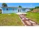 Charming blue home with a stone pathway leading to the backyard and patio at 6432 Boatyard Dr, Hudson, FL 34667