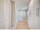Hallway with herringbone wood-look tile floors, a closet, and white storage cabinets, offering ample storage space at 6432 Boatyard Dr, Hudson, FL 34667