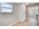 Bright hallway featuring herringbone floors and a white storage cabinet, leading into an open-concept kitchen at 6432 Boatyard Dr, Hudson, FL 34667