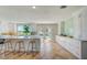Bright kitchen boasts a large marble island, modern cabinetry, and wood floors at 6432 Boatyard Dr, Hudson, FL 34667