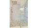 Modern bathroom shower featuring river rock flooring and a sleek glass enclosure at 6432 Boatyard Dr, Hudson, FL 34667