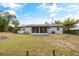 The backyard features a spacious lawn, a covered patio, and a privacy fence at 7365 Pinehurst Dr, Spring Hill, FL 34606