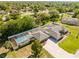 An aerial view showcasing a private pool, lush landscaping, and a paved driveway at 7466 Jonquil Pl, Weeki Wachee, FL 34607
