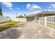 Private backyard features a paver patio, lush lawn, and white vinyl perimeter fencing at 7466 Jonquil Pl, Weeki Wachee, FL 34607