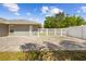 This backyard features a spacious brick paver patio, lush lawn, and white vinyl fencing at 7466 Jonquil Pl, Weeki Wachee, FL 34607