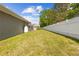 Spacious backyard features green grass, white fencing, and a screened pool, creating a serene outdoor oasis at 7466 Jonquil Pl, Weeki Wachee, FL 34607