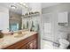 Neutral bathroom featuring a wood vanity, shelves, and a tiled shower at 7466 Jonquil Pl, Weeki Wachee, FL 34607