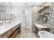 Bright bathroom features wood shelving, decorative mirror and modern dual-faucet sink at 7466 Jonquil Pl, Weeki Wachee, FL 34607