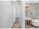 Open doorway reveals a tiled bathroom featuring a standalone tub and decorative backsplash at 7466 Jonquil Pl, Weeki Wachee, FL 34607