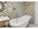 An elegant clawfoot tub is featured in this stylish bathroom with unique tile at 7466 Jonquil Pl, Weeki Wachee, FL 34607