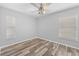 Bedroom featuring wood-look floors, neutral walls, ceiling fan, and windows on two walls at 7466 Jonquil Pl, Weeki Wachee, FL 34607