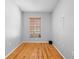 A cozy bedroom features hardwood floors, neutral paint, and a window with blinds at 7466 Jonquil Pl, Weeki Wachee, FL 34607