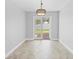 Bright dining area featuring tile flooring, a modern light fixture, and access to the backyard at 7466 Jonquil Pl, Weeki Wachee, FL 34607
