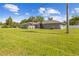 Charming single-story home with a well-manicured lawn and elegant gray exterior, complemented by swaying palm trees at 7466 Jonquil Pl, Weeki Wachee, FL 34607