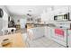 This bright kitchen with white cabinetry, tile floor and stainless appliances offers a comfortable cooking experience at 7466 Jonquil Pl, Weeki Wachee, FL 34607