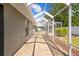 A brick paver patio leads toward a lanai and screened in pool area at 7466 Jonquil Pl, Weeki Wachee, FL 34607
