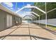 A brick paver patio runs along the backyard toward the screened in lanai and pool at 7466 Jonquil Pl, Weeki Wachee, FL 34607